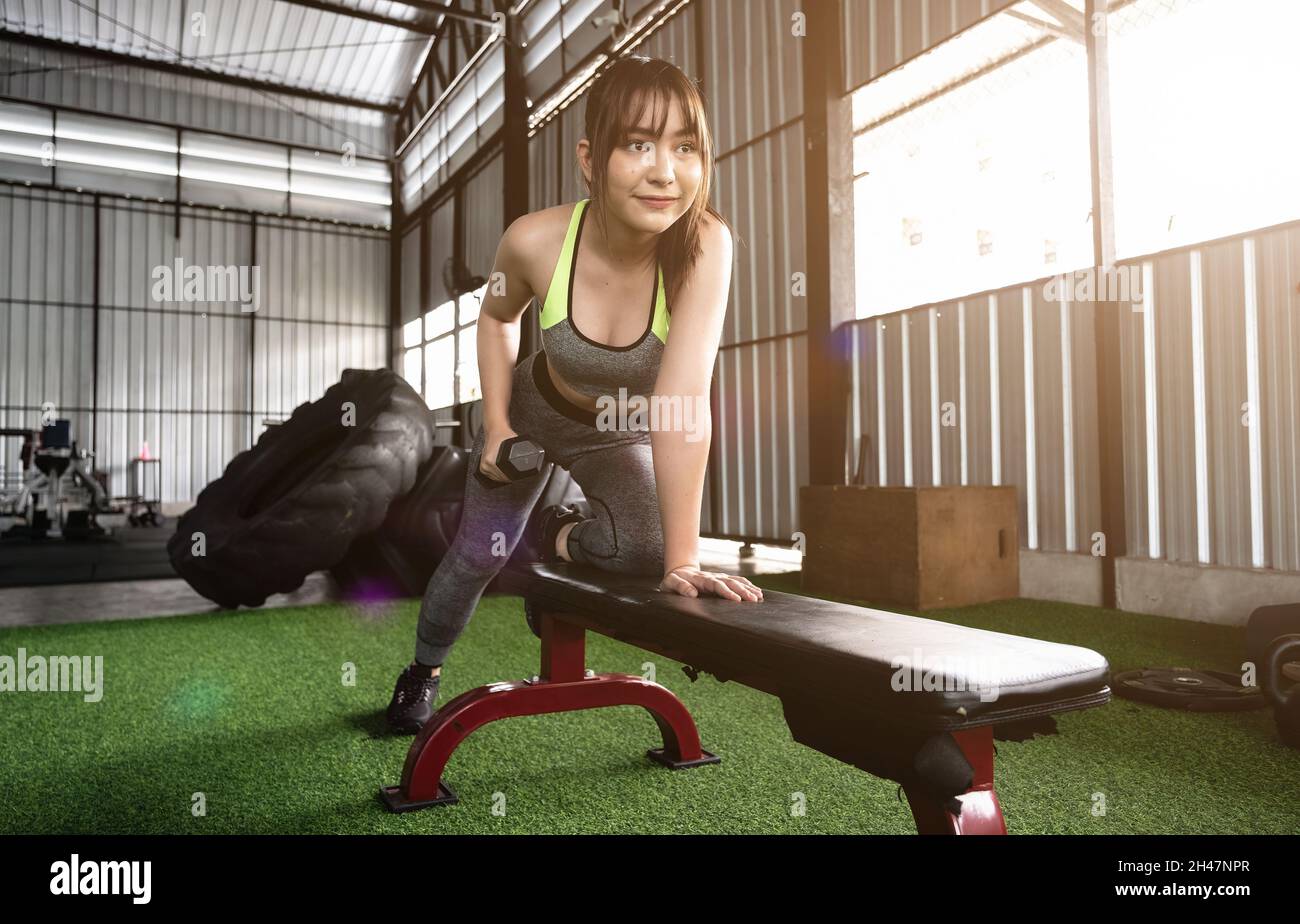 Une femme asiatique stupéfiante se concentre sur lever un haltère à la salle de gym. Musculation Banque D'Images