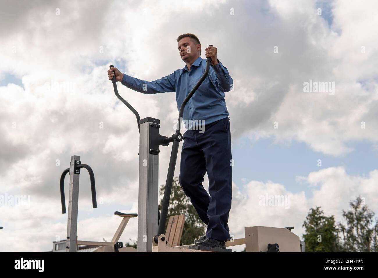 Beau jeune homme en costume noir, chemise blanche et entraînement de cravate dans la salle de gym Banque D'Images