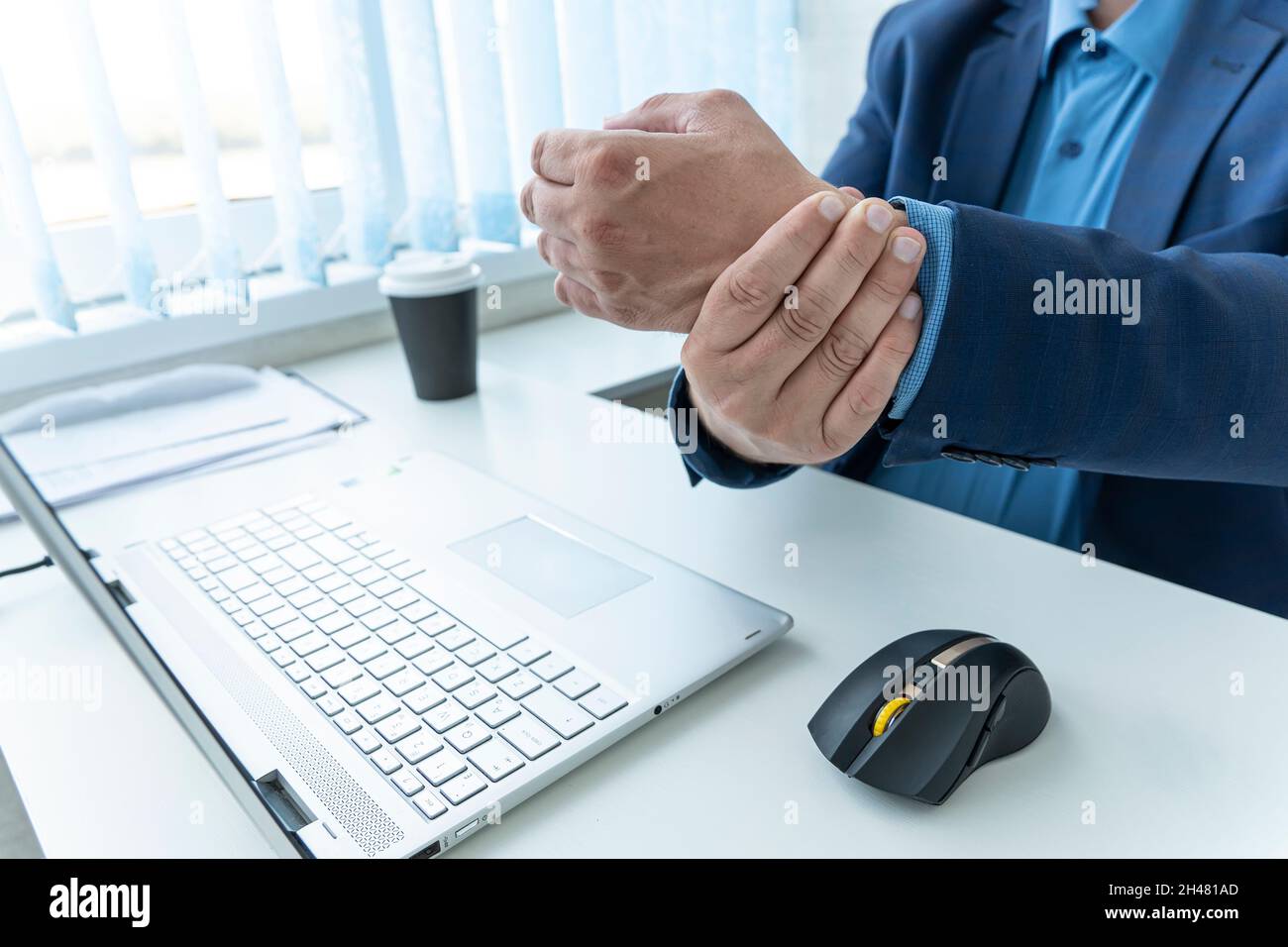 homme d'affaires souffrant de douleurs au poignet. un employé ressent de la douleur au poignet après avoir travaillé au clavier pendant une longue période. Banque D'Images