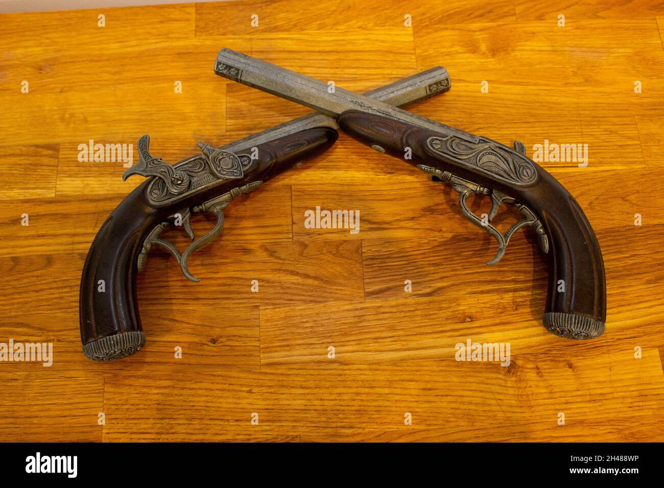 Vue de dessus de deux pistolets anciens en forme de flintlock sur une table en bois Banque D'Images