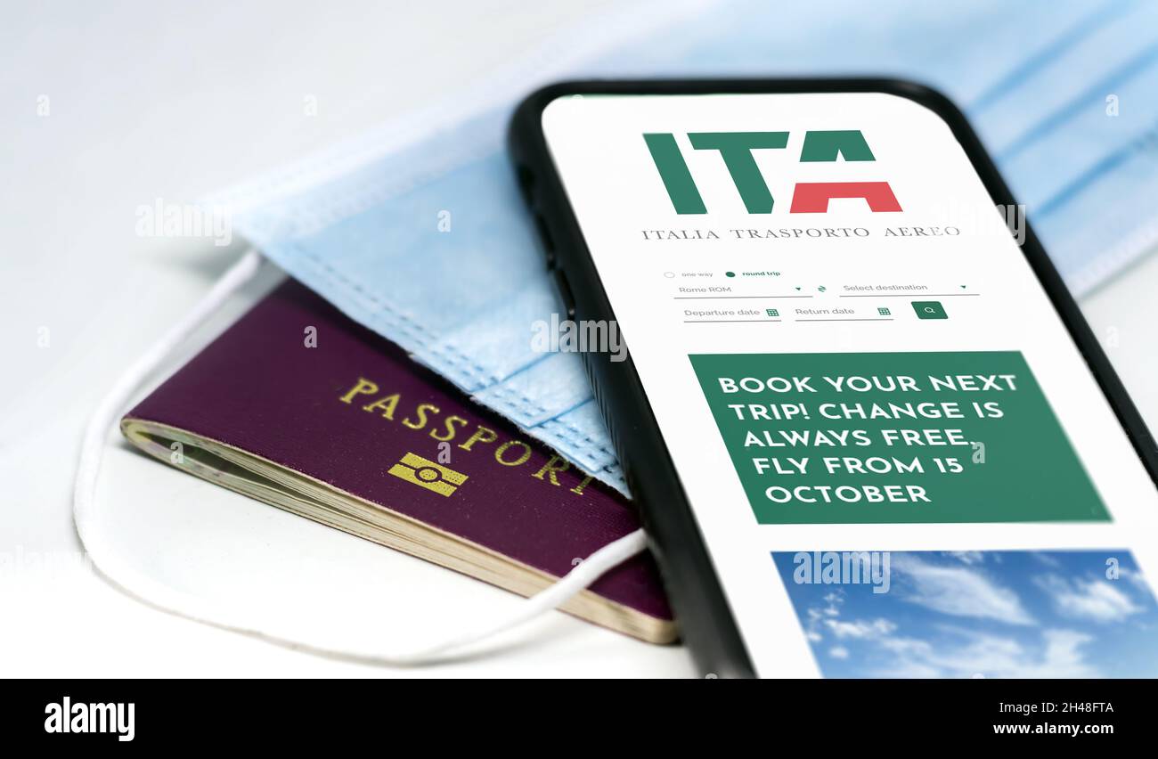 Rome, Italie, octobre 2021: Téléphone avec l'application ITA à l'écran sur un masque chirurgical et un passeport.ITA est le nouveau transporteur italien à partir de Banque D'Images