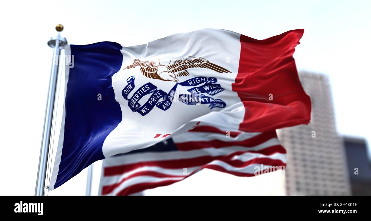 Le drapeau de l'État américain de l'Iowa agitant dans le vent avec les étoiles et les bandes américaines drapeau flou dans l'arrière-plan.Trois bandes verticales.Le ce Banque D'Images