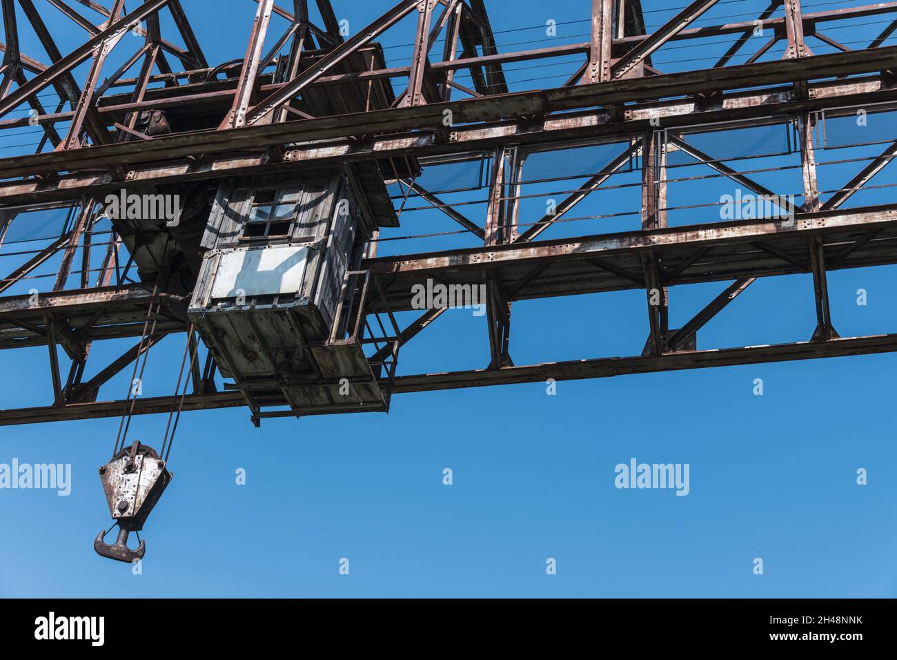 grue portique robuste rouillée ancienne avec crochet massif et cabine de l'opérateur contre le ciel bleu Banque D'Images