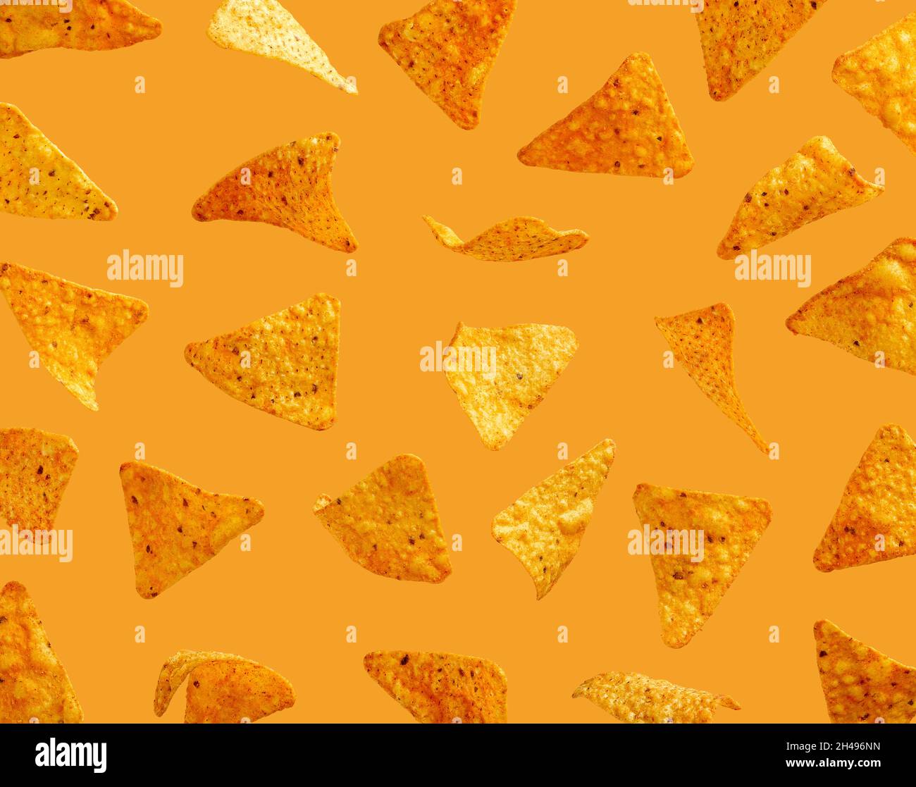 Grains de maïs nachos volant dans l'air sur fond orange Banque D'Images