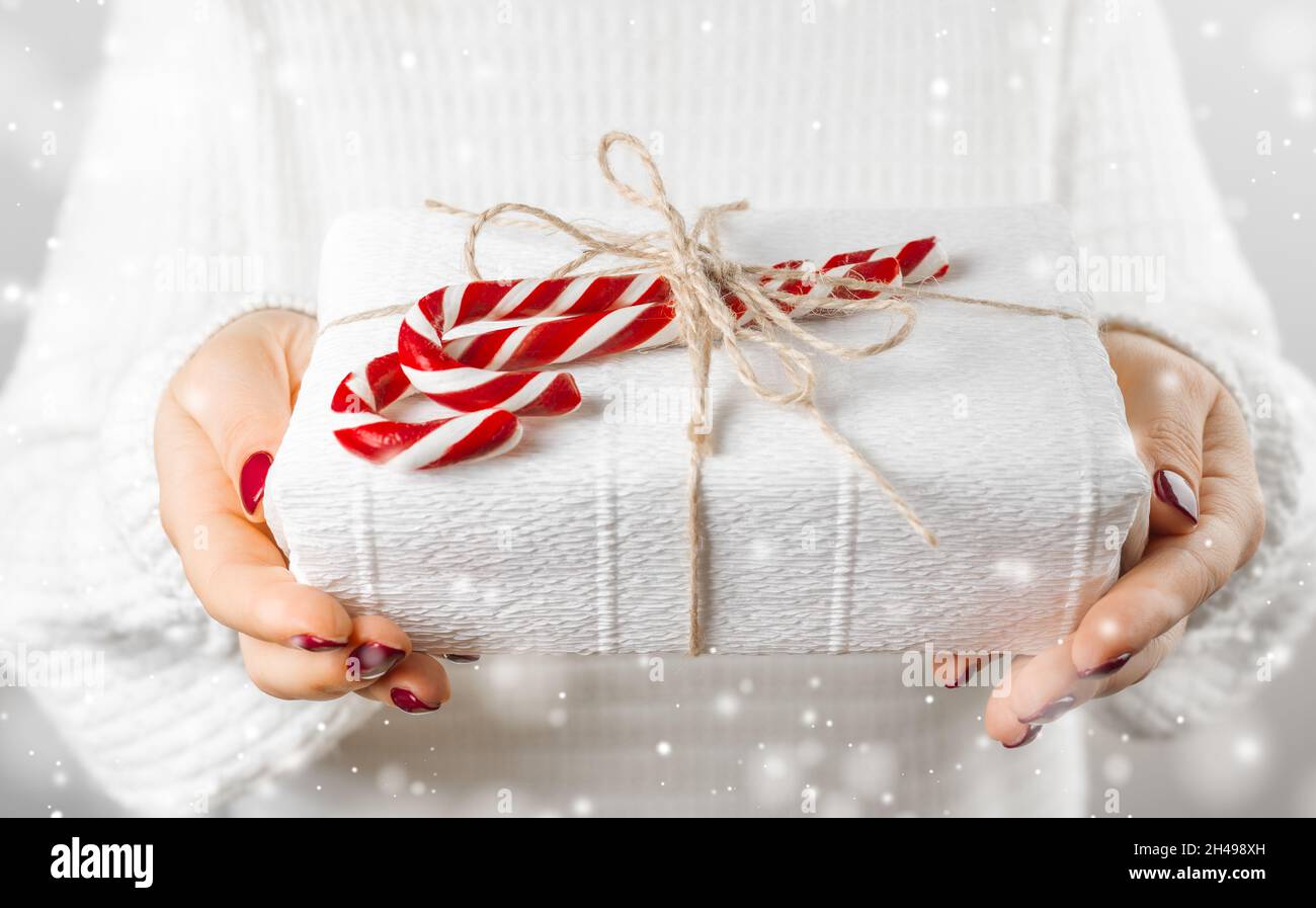 Cadeau offert, cadeau fait main enveloppé dans du papier.Femme avec un  cadeau de Noël en main Photo Stock - Alamy