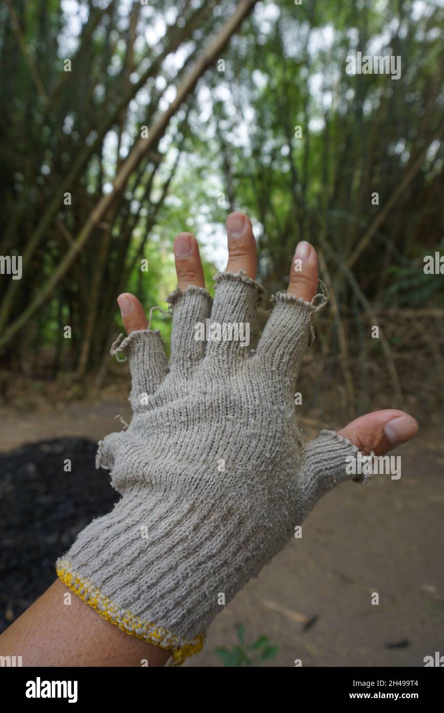 Mains avec trous et gants cassés Banque D'Images