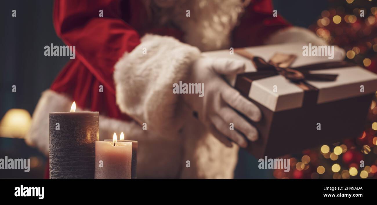 Le Père Noël apporte des cadeaux à la maison la veille de Noël, il tient un  beau cadeau Photo Stock - Alamy