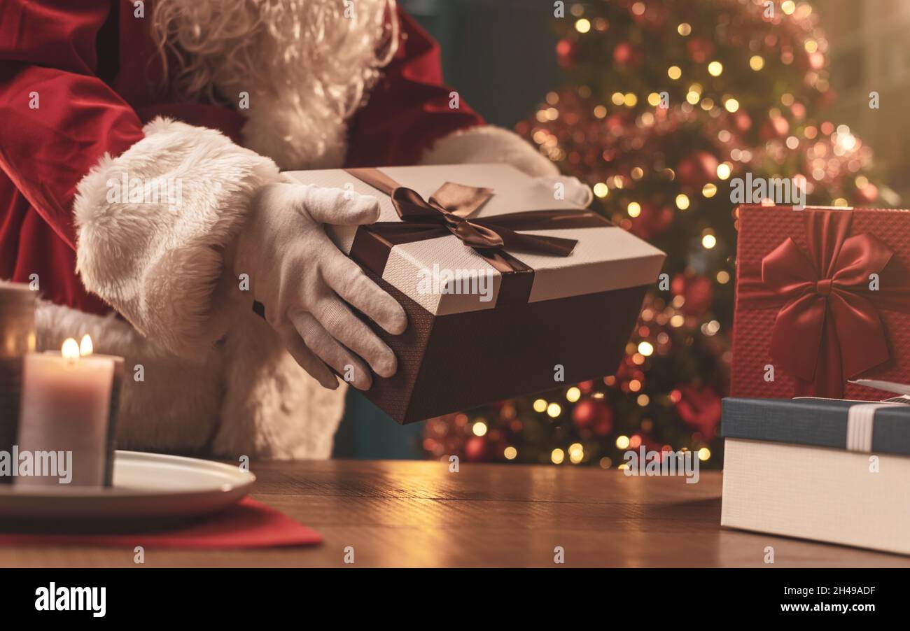 Le Père Noël apporte des cadeaux à la maison la veille de Noël, il tient un  beau cadeau Photo Stock - Alamy