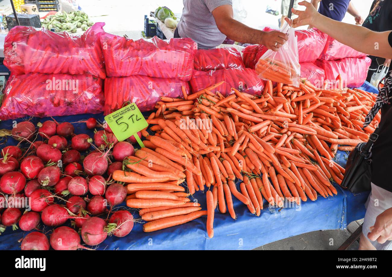Femme achetant des légumes frais biologiques, des carottes et des radis au marché du bazar du village à Manavgat, Antalya, Turquie. Banque D'Images