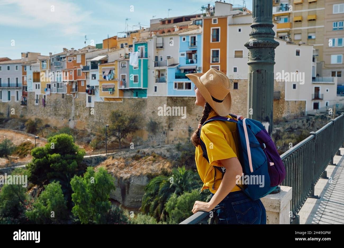 Concept de voyage. Voyageur dans un chapeau de paille regardant la belle ville de Villajoyosa avec de belles maisons colorées et des bâtiments Banque D'Images