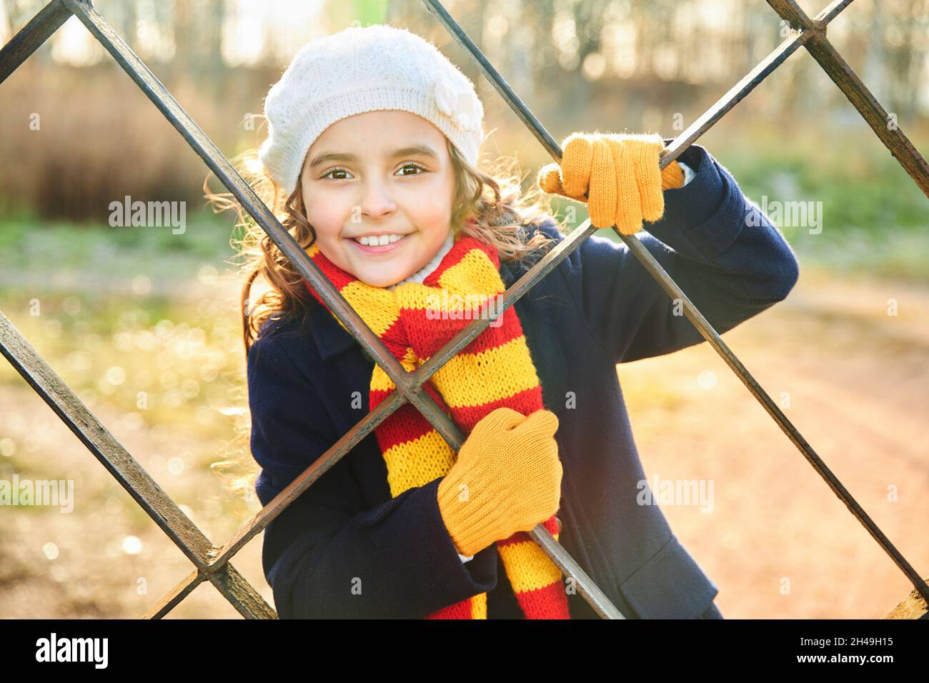 petite fille en manteau bleu derrière une treillis métallique dans le parc  en automne.Photo de haute qualité Photo Stock - Alamy