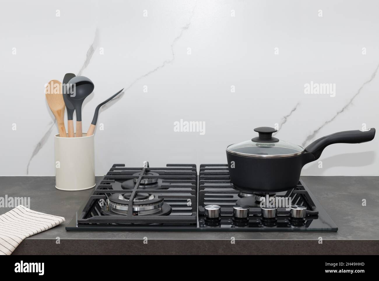 Plaque de cuisson sur cuisinière à gaz contre carreaux muraux en marbre  blanc Photo Stock - Alamy