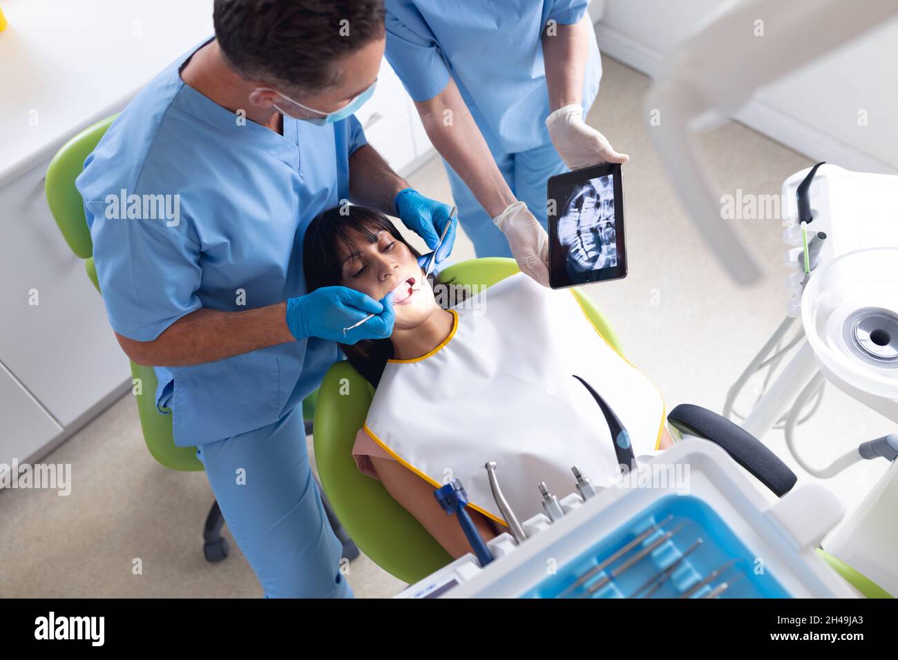 Dentiste mâle caucasien et infirmière dentaire féminine examinant les dents du patient à la clinique dentaire moderne Banque D'Images