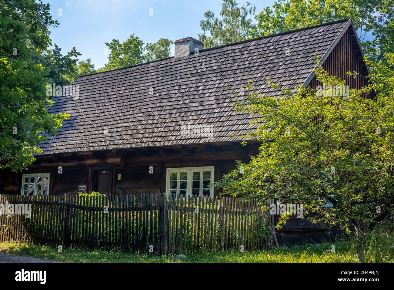 OPOLE, POLOGNE - 20 juin 2021: Chalet traditionnel en bois avec clôture en bois, entouré d'arbres. Banque D'Images