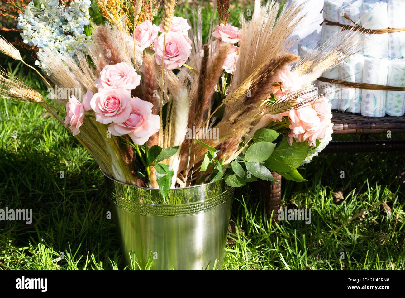 seau de douche pour bébé avec bouquet de fleurs et couches Banque D'Images