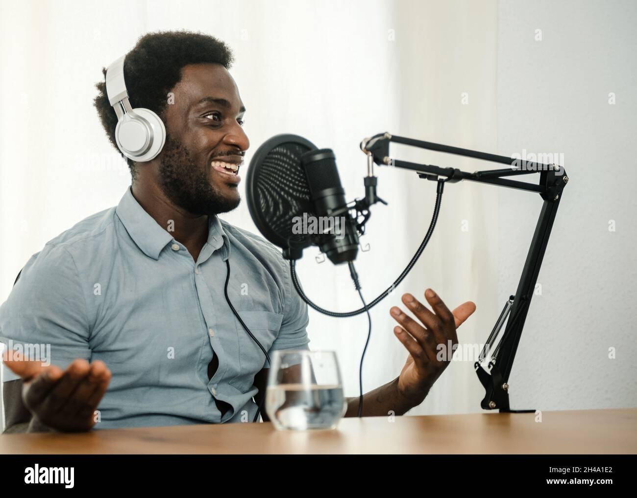 Black man enregistrant le podcast et la gesticulation Banque D'Images