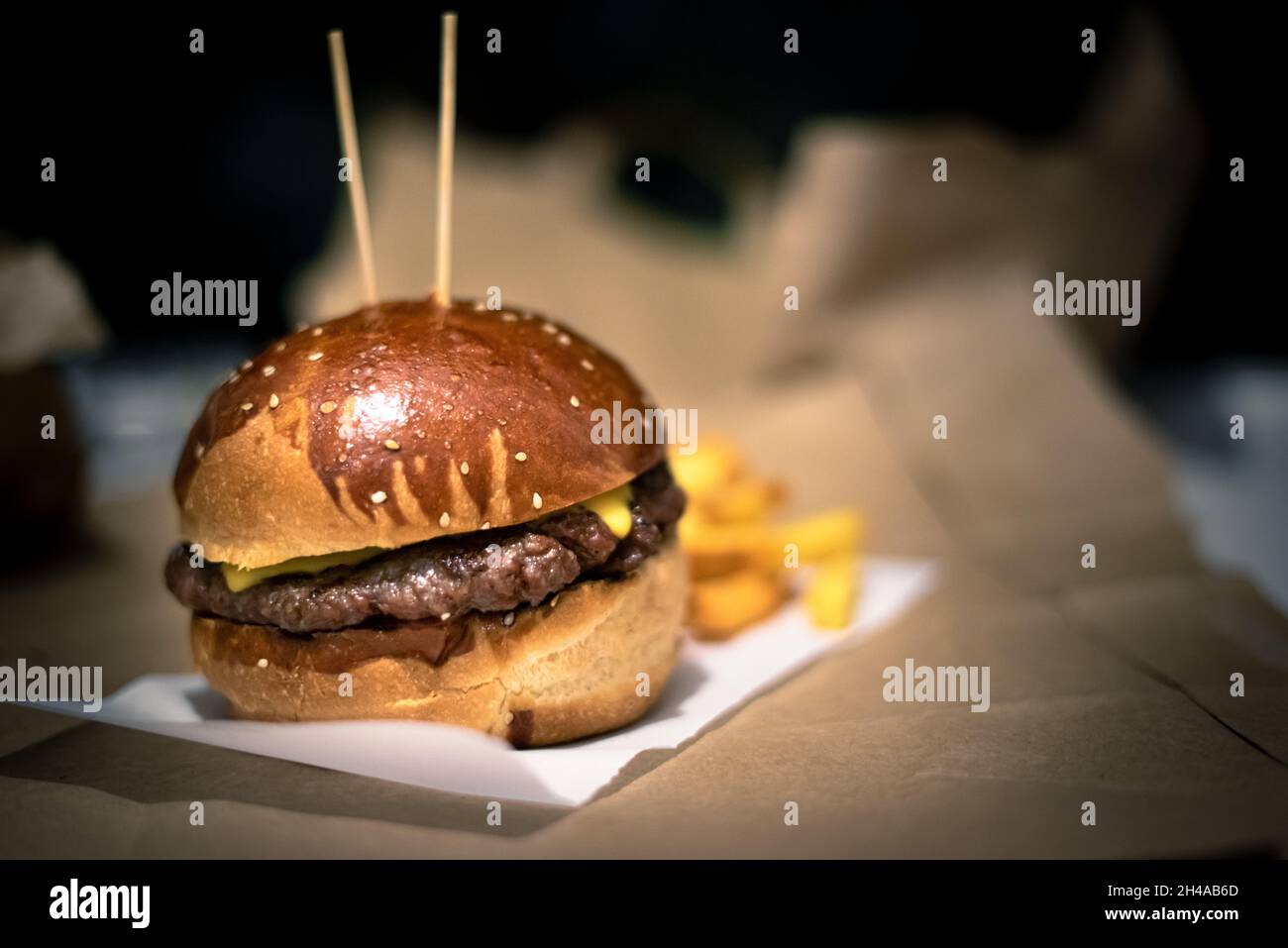 Cheeseburger sur papier avec pomme de terre Banque D'Images