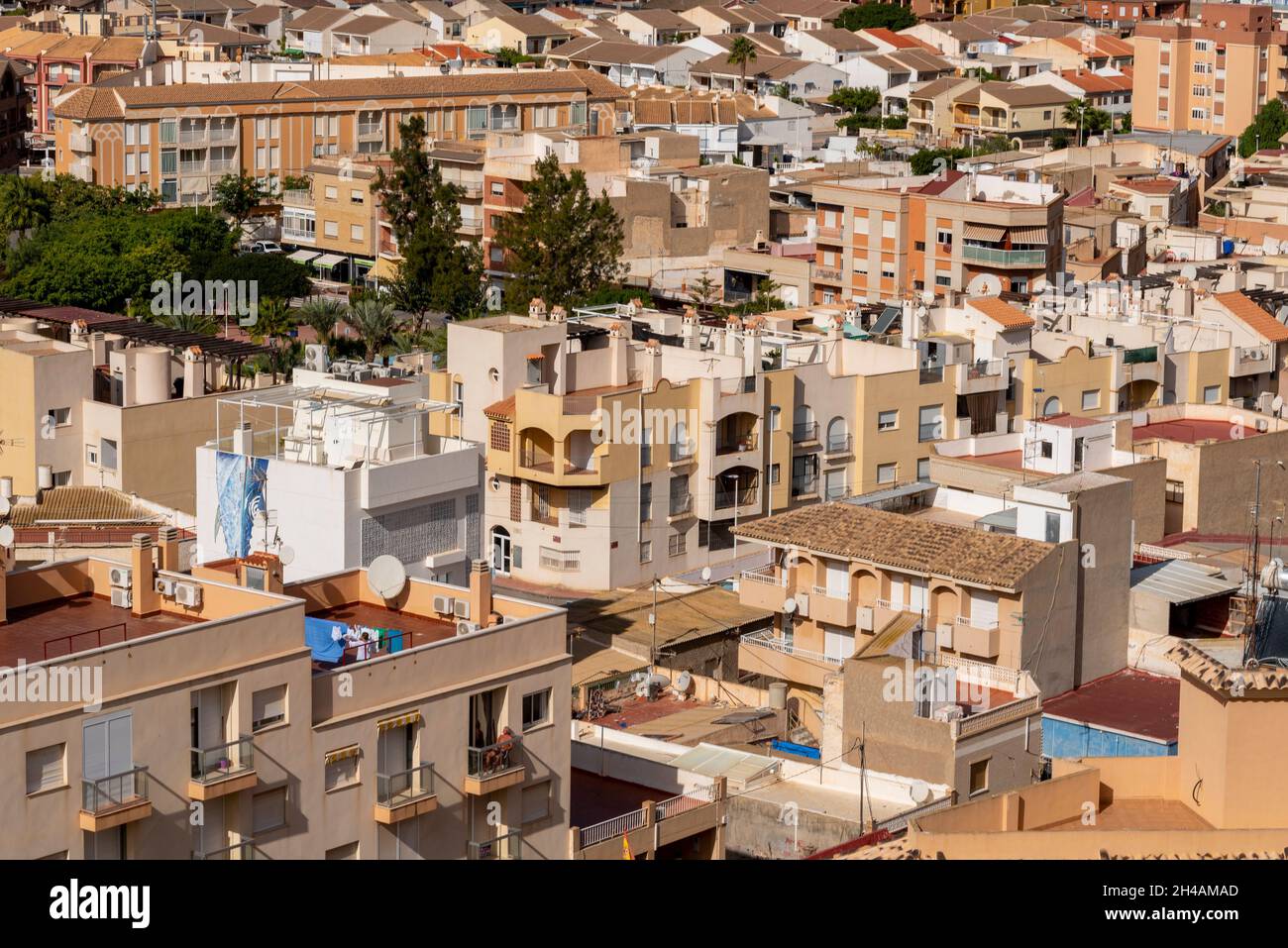 Vue sur la ville de Puerto de Mazarron, Murcia, Espagne, avec des toits, un solarium sur un balcon et une femme qui se lavoir Banque D'Images