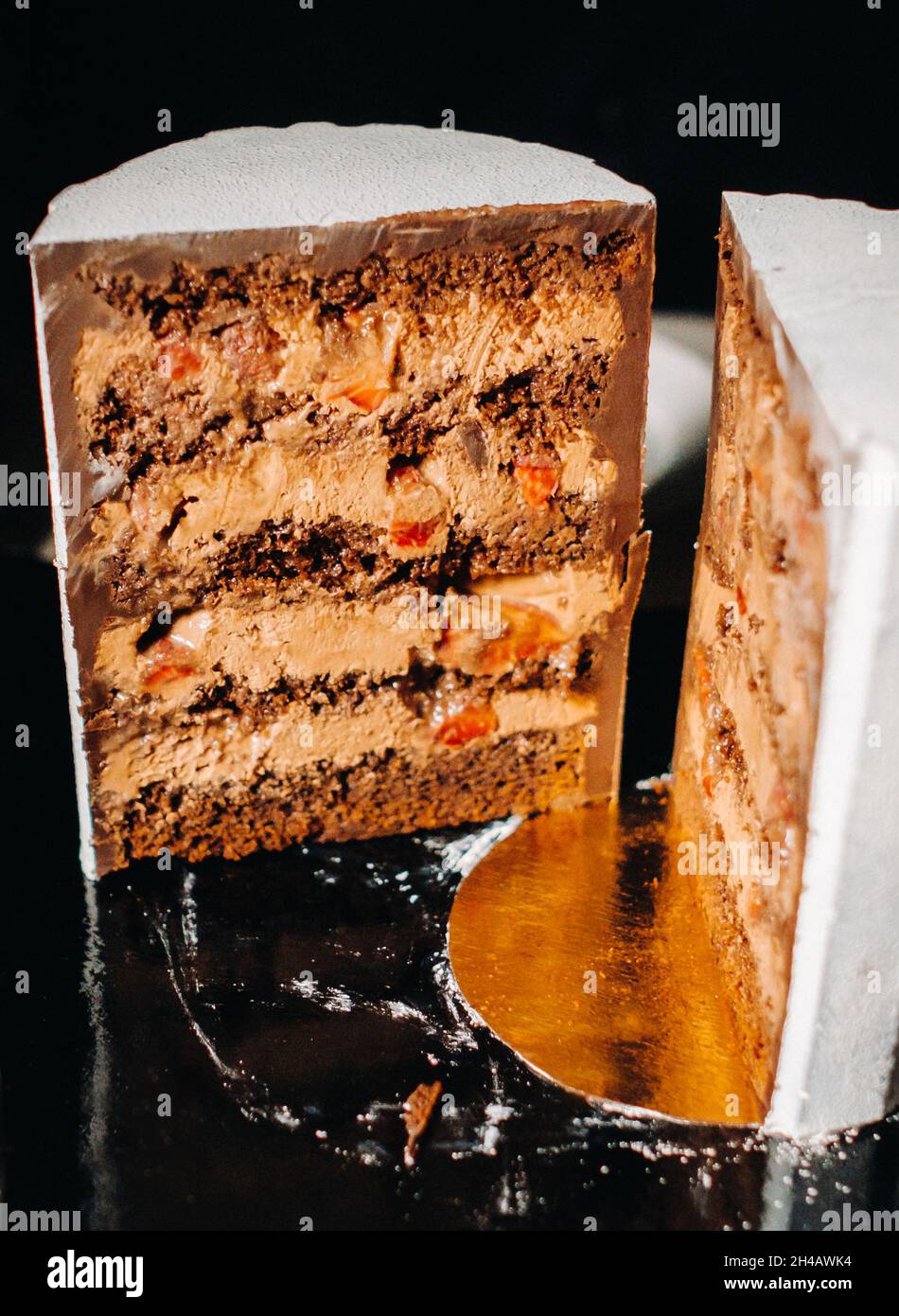 Des gâteaux incroyables.Gâteau de mariage en tranches de chocolat avec garniture étonnante sur fond noir. Grand gâteau au chocolat blanc. Banque D'Images
