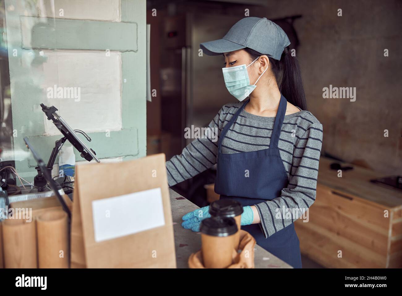 Femme employeur vérifiant la commande près du comptoir du café Banque D'Images