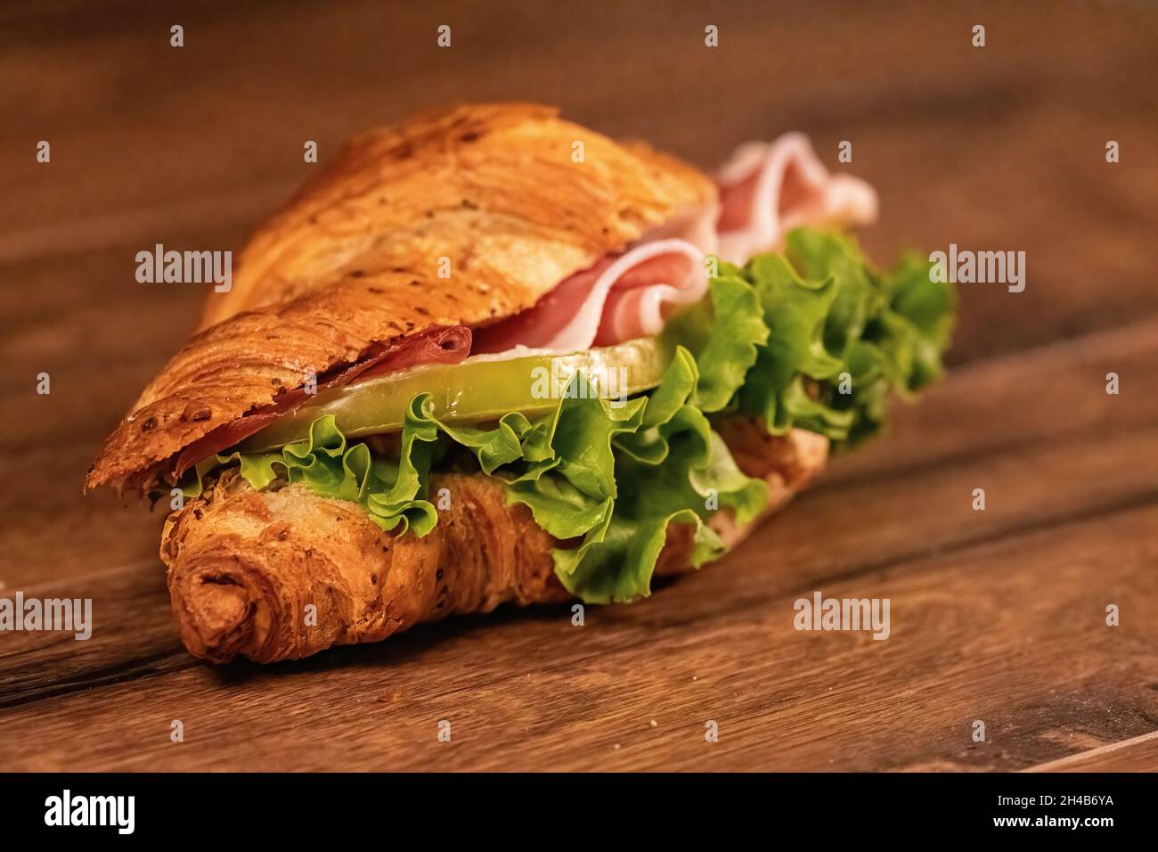 sandwich avec salami et légumes sur une surface en bois Banque D'Images