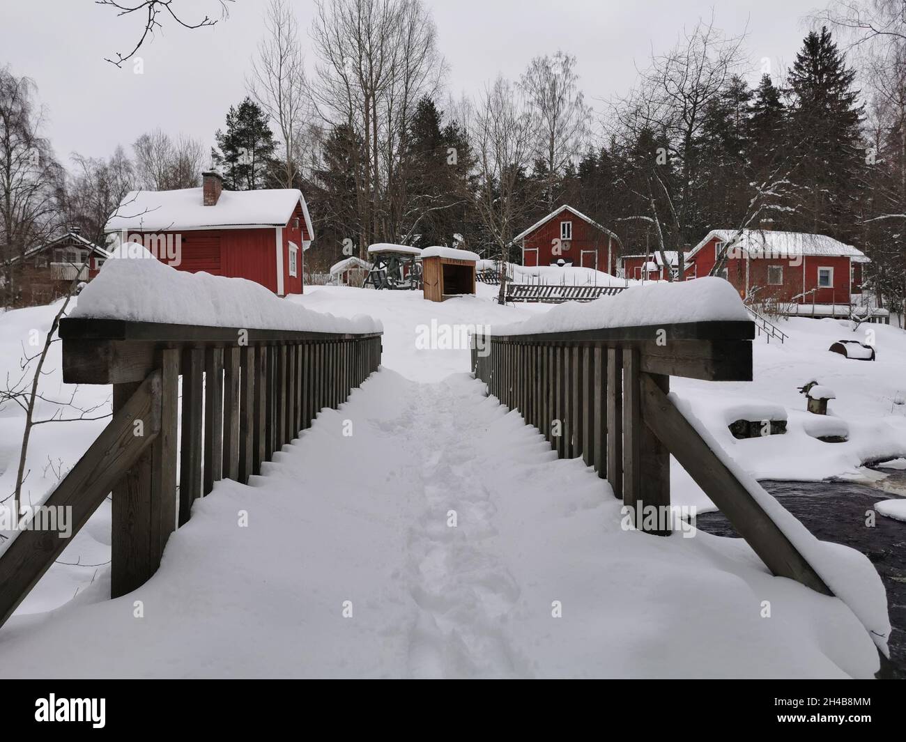 Chalets en bois rouge dans une forêt.Météo enneigée. Banque D'Images
