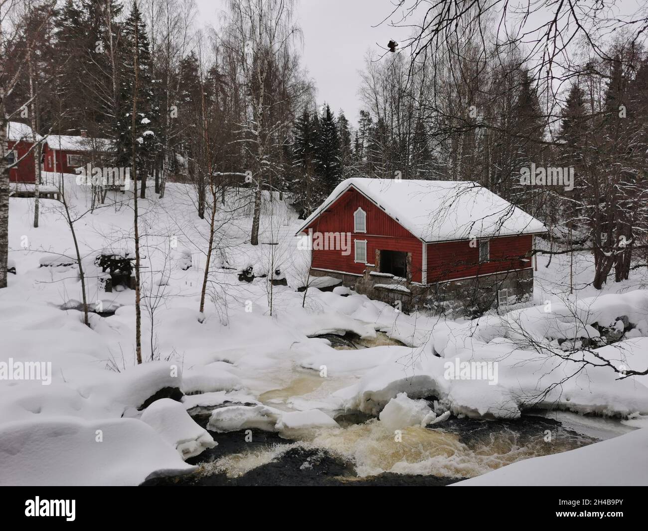 Chalets en bois rouge dans une forêt.Météo enneigée. Banque D'Images