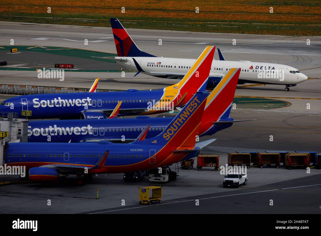 Los Angeles, Californie, États-Unis.28 mars 2019.Southwest Airlines Co. Boeing Co. 737 se tient à leurs portes en tant que Delta Air Line Boeing Co. 737-900 (enregistrement N919DU) taxis sur le tarmac à l'aéroport international de Los Angeles (LAX) le jeudi 28 mars 2019 à Los Angeles, en Californie © 2019 Patrick T. Fallon (Credit image:© Patrick Fallon/ZUMA Press Wire) Banque D'Images