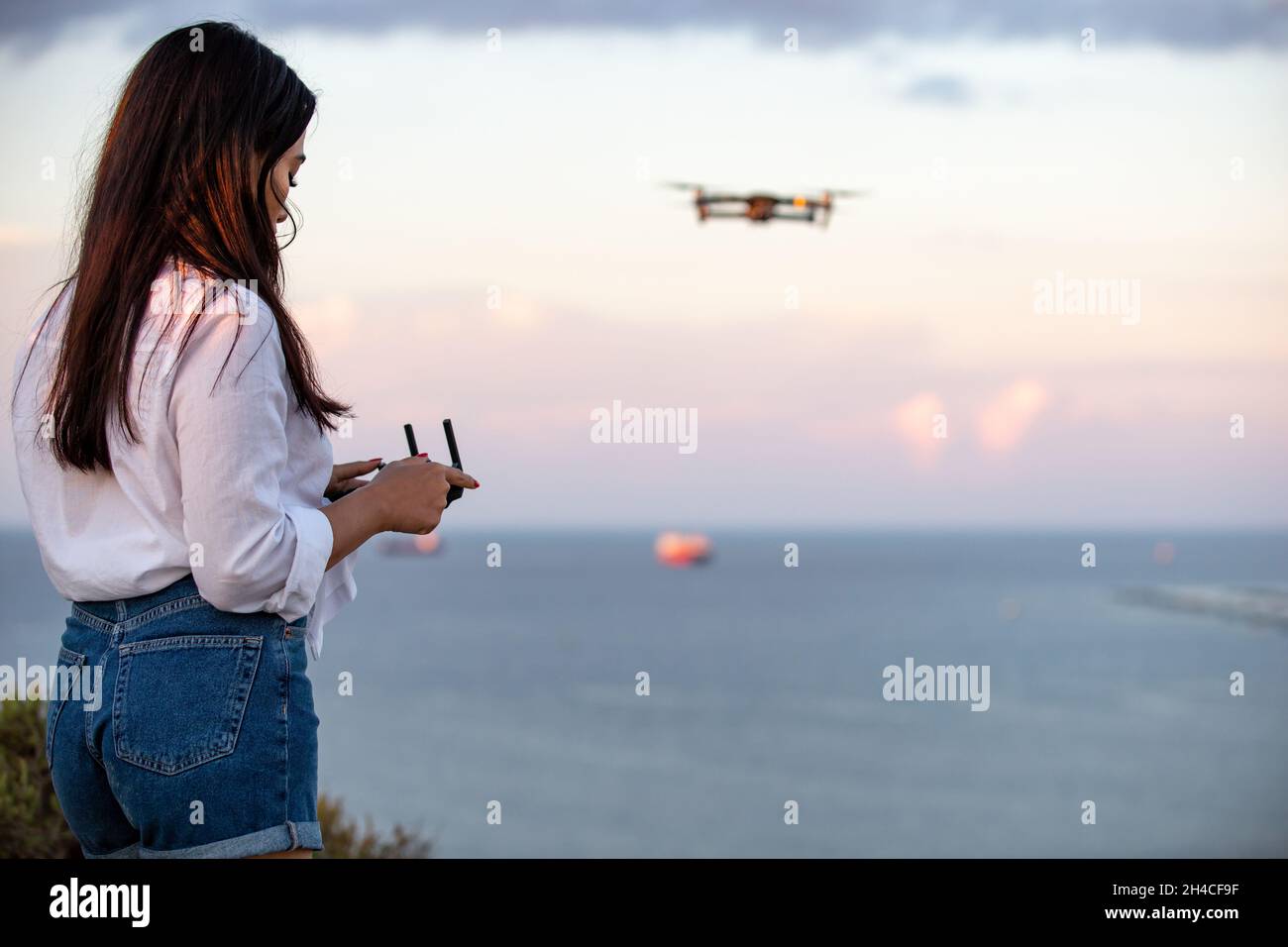 Une jeune femme utilisant un drone UAV Banque D'Images