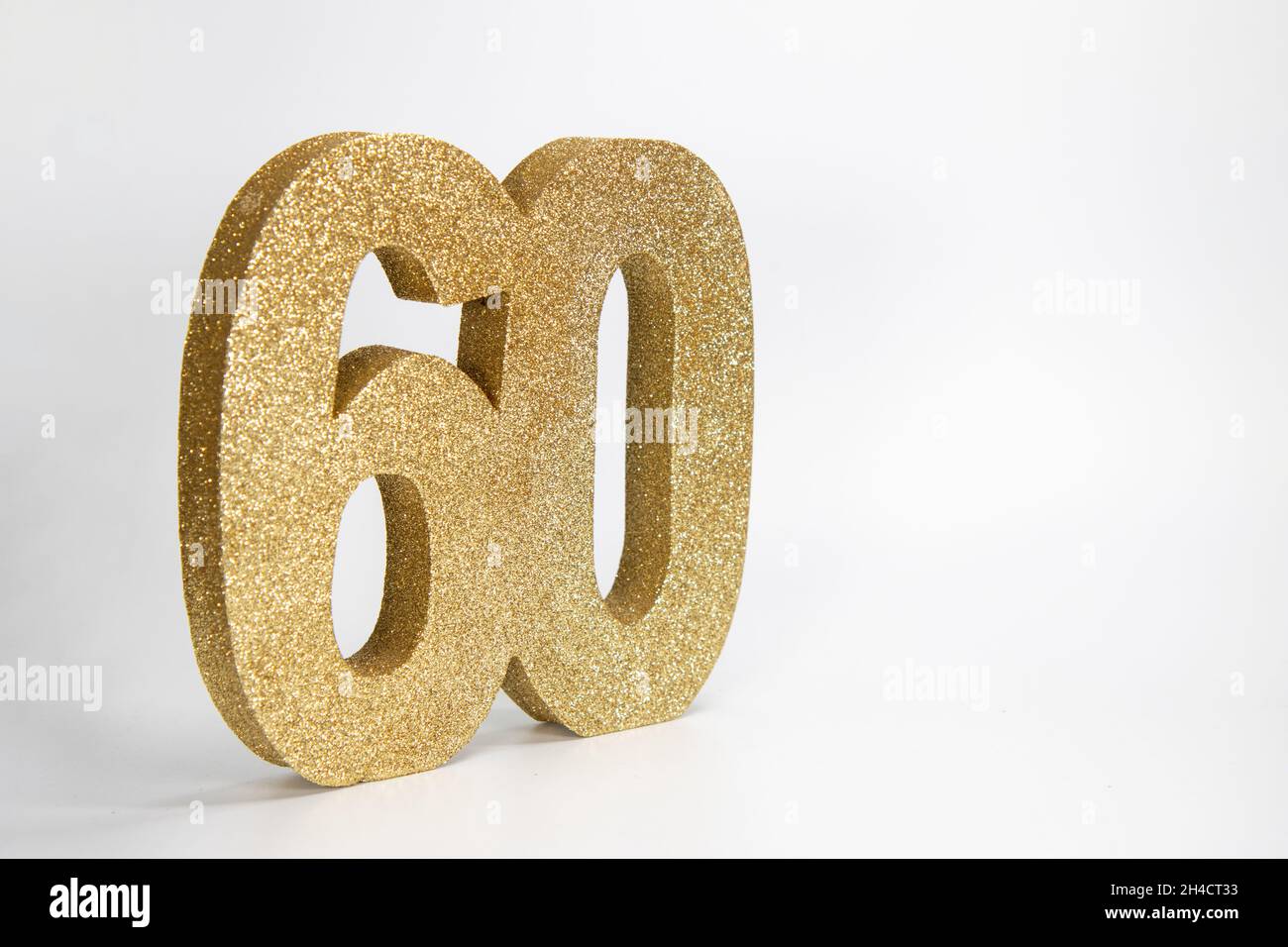 Un signe de paillettes dorées qui indique le numéro 60 sur fond blanc, le 60e anniversaire ou le concept d'anniversaire Banque D'Images