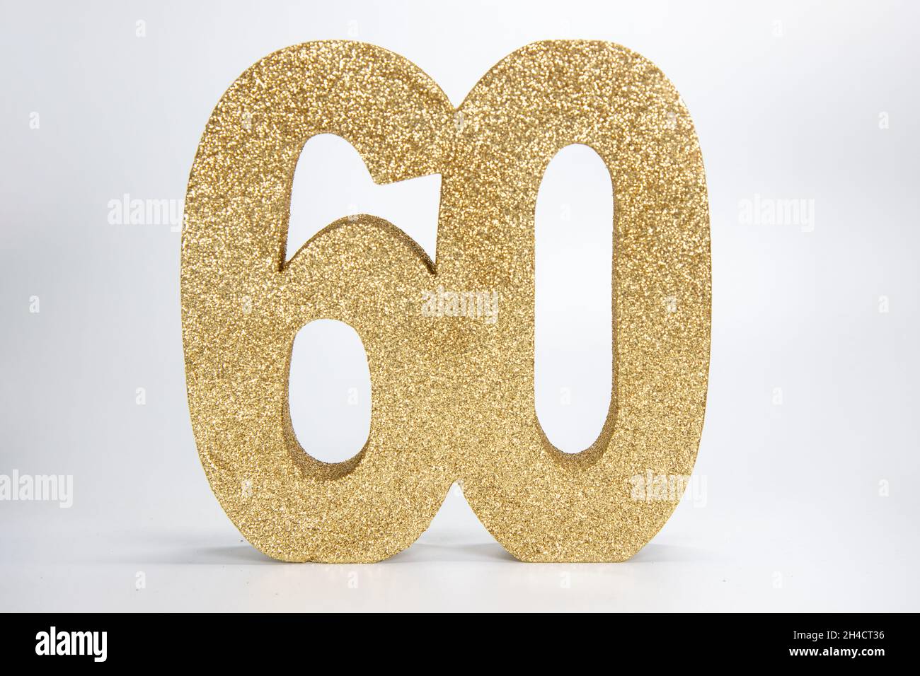 Un signe de paillettes dorées qui indique le numéro 60 sur fond blanc, le 60e anniversaire ou le concept d'anniversaire Banque D'Images