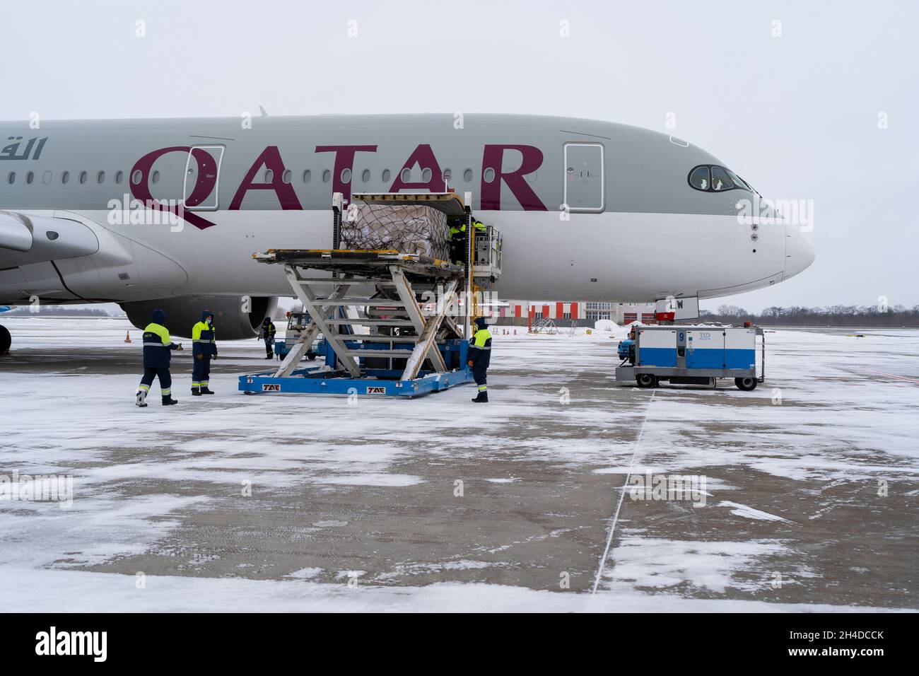 Ukraine, Kiev - 12 février 2021 : chargement de bagages dans le coffre à bagages de l'avion.Aéroport d'hiver.Un AIRBUS A350-900 de Qatar Airlines A7-ALW.Avion et neige.Chargement Banque D'Images