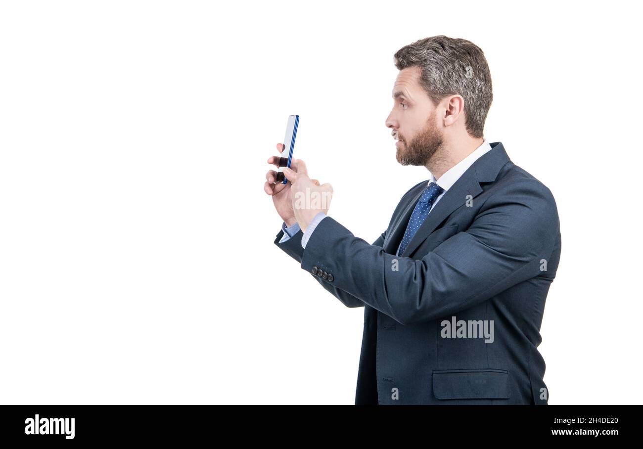 Homme d'affaires en costume de point de doigt sur le téléphone mobile isolé sur l'espace de copie blanc, pointant Banque D'Images