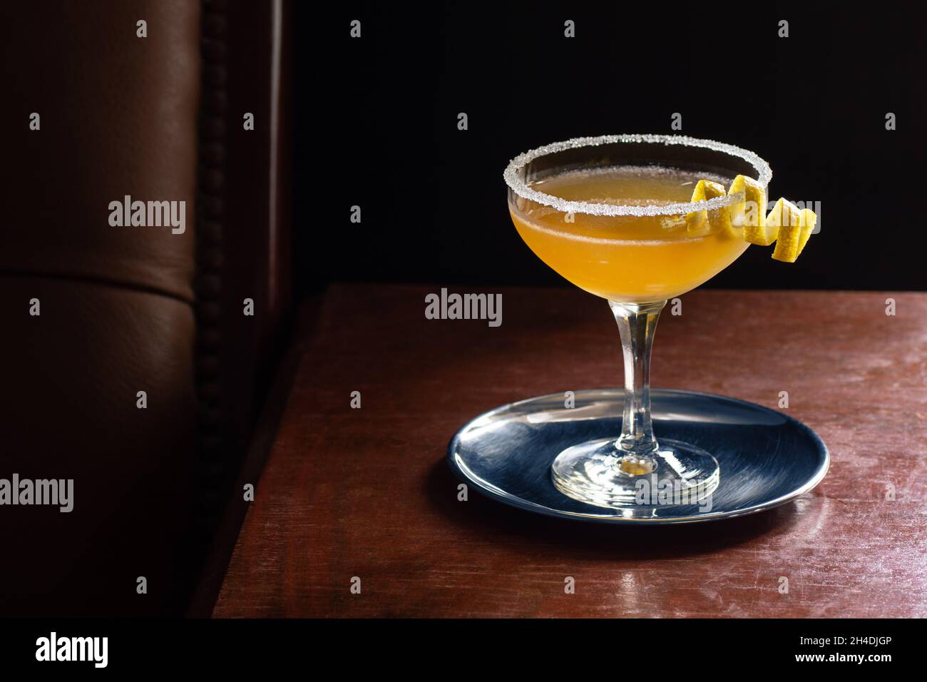 Cocktail de side-car avec rebord sucré en verre coupé dans un bar luxueux et sombre avec espace de copie Banque D'Images