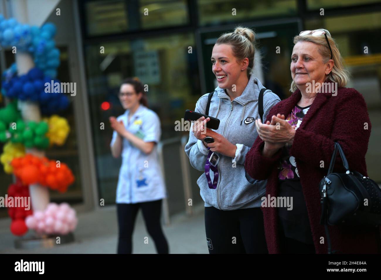Un travailleur du NHS et des habitants de la région à l'extérieur de l'hôpital Whittington, dans le nord de Londres, se joignent aux applaudissements pour saluer les héros locaux lors du Clap national de jeudi pour que les soignants reconnaissent et soutiennent les travailleurs du NHS et les soignants qui luttent contre la pandémie du coronavirus.Date de la photo : jeudi 30 avril 2020. Banque D'Images