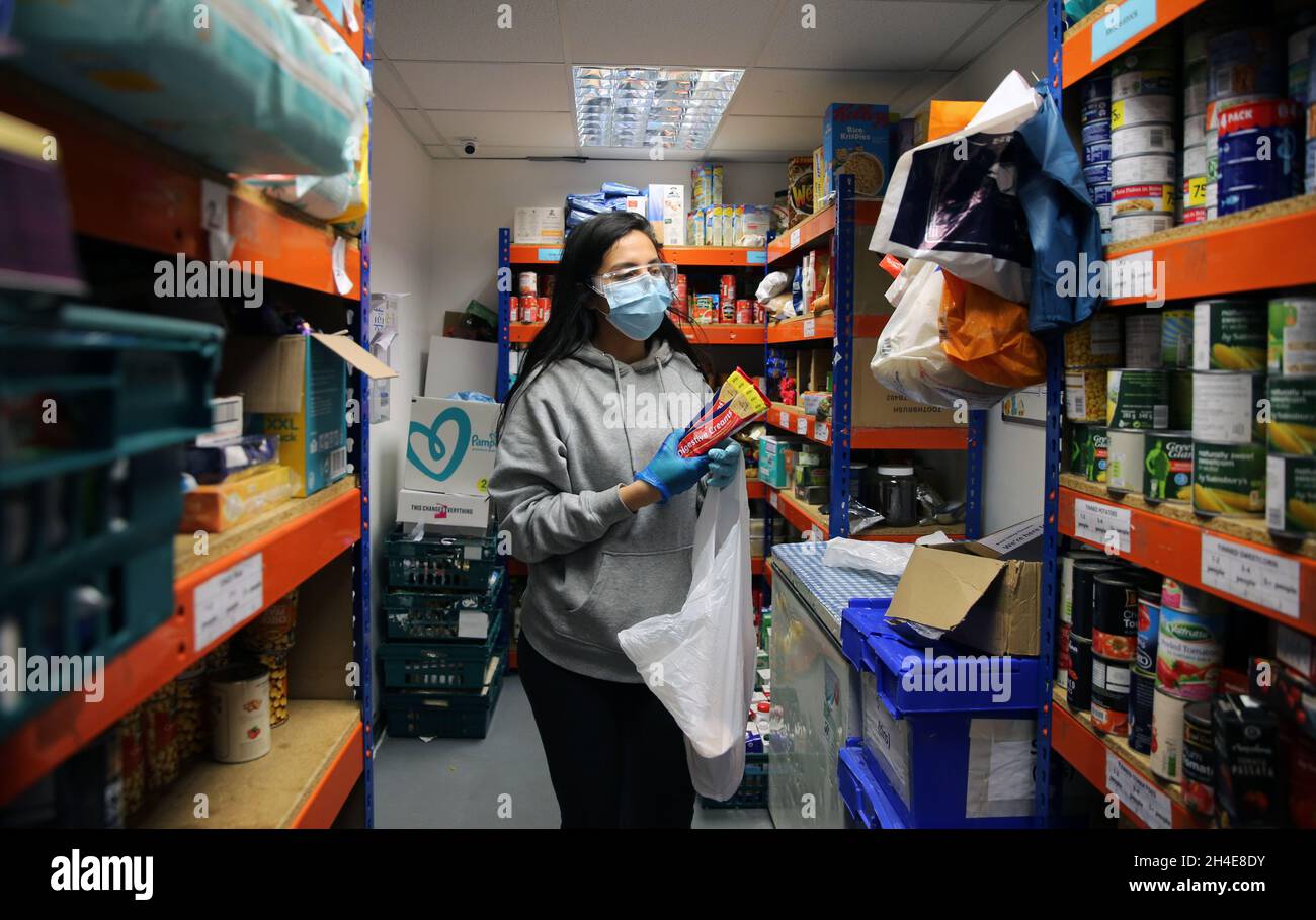 Un volontaire portant un équipement personnel de protection (EPI) organise des colis de nourriture à la banque alimentaire Sufra NW London à Neasden, qui fournit des fournitures d'urgence de nourriture essentielle aux personnes et aux familles qui luttent pendant le confinement.Date de la photo: Vendredi 15 mai 2020 Banque D'Images