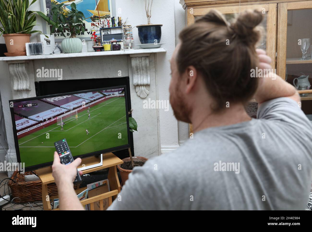 Un fan de football du nord de Londres regarde à la télévision le match Aston Villa contre Sheffield United Premier League.La Premier League est revenue mercredi derrière des portes fermées, alors que d'autres restrictions de verrouillage du coronavirus sont levées en Angleterre.Date de la photo: Mercredi 17 juin 2020. Banque D'Images