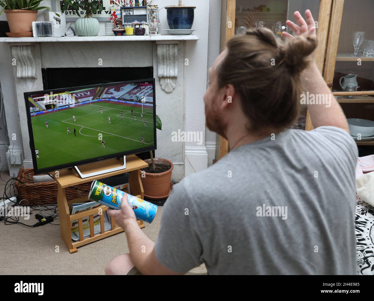 Un fan de football du nord de Londres regarde à la télévision le match Aston Villa contre Sheffield United Premier League.La Premier League est revenue mercredi derrière des portes fermées, alors que d'autres restrictions de verrouillage du coronavirus sont levées en Angleterre.Date de la photo: Mercredi 17 juin 2020. Banque D'Images