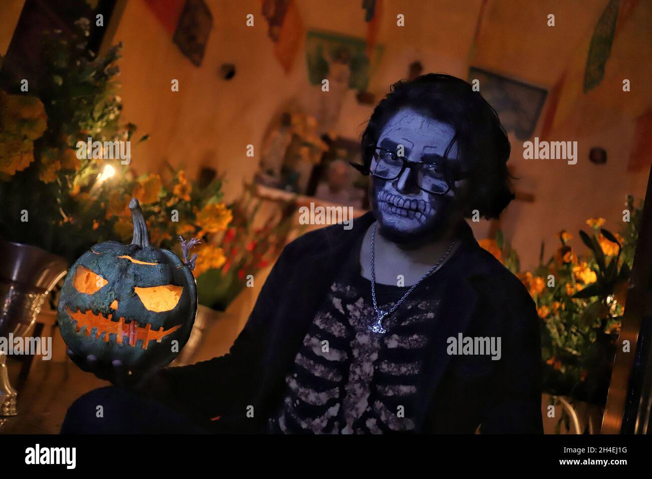 Une personne tient une soirée au cimetière de San Pedro Tláhuac, pour attendre l'arrivée de leurs proches décédés, les parents décorent avec des fleurs,Apportez-leur de la nourriture et chantez-leur aux tombes comme traditions mexicaines du jour des morts pour leur souhaiter un bon retour sur la route de Mictlan.Le 1er novembre 2021 à Mexico, Mexique.(Photo de Fernanda Rojas/ Eyepix Group) Banque D'Images