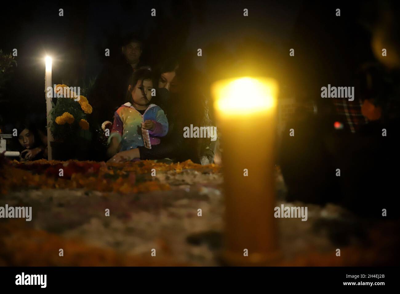 Une personne tient une soirée au cimetière de San Pedro Tláhuac, pour attendre l'arrivée de leurs proches décédés, les parents décorent avec des fleurs,Apportez-leur de la nourriture et chantez-leur aux tombes comme traditions mexicaines du jour des morts pour leur souhaiter un bon retour sur la route de Mictlan.Le 1er novembre 2021 à Mexico, Mexique.(Photo de Fernanda Rojas/ Eyepix Group) Banque D'Images