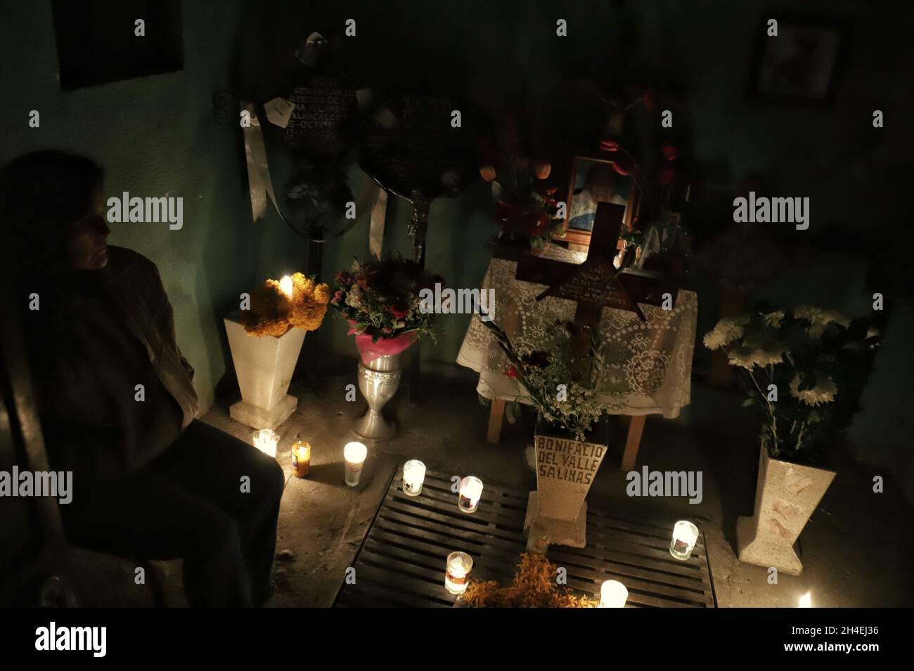 Une personne tient une soirée au cimetière de San Pedro Tláhuac, pour attendre l'arrivée de leurs proches décédés, les parents décorent avec des fleurs,Apportez-leur de la nourriture et chantez-leur aux tombes comme traditions mexicaines du jour des morts pour leur souhaiter un bon retour sur la route de Mictlan.Le 1er novembre 2021 à Mexico, Mexique.(Photo de Fernanda Rojas/ Eyepix Group) Banque D'Images