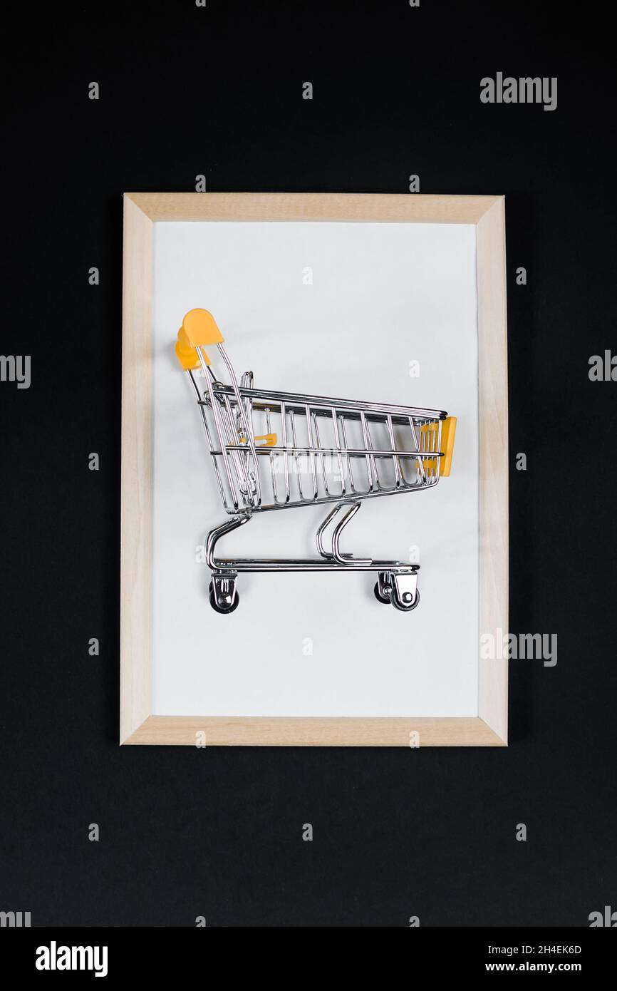 Solde du Vendredi fou.Mini panier dans le cadre sur fond noir.Bannière publicitaire. Banque D'Images