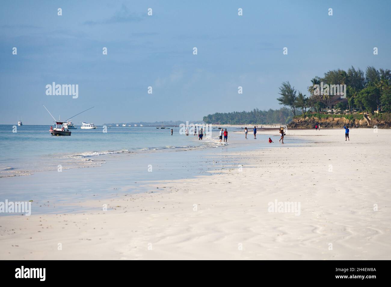 Vue sur la plage de Diani avec les touristes et les habitants qui marchent sur la plage tôt le matin, Diani, Kenya Banque D'Images