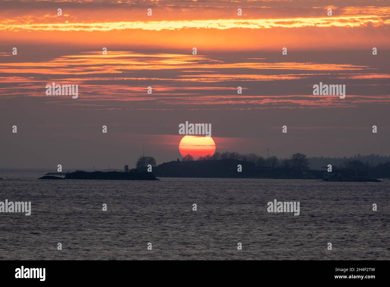 Helsinki / Finlande - 2 NOVEMBRE 2021 : une silhouette d'un petit skerry contre un magnifique coucher de soleil coloré. Banque D'Images