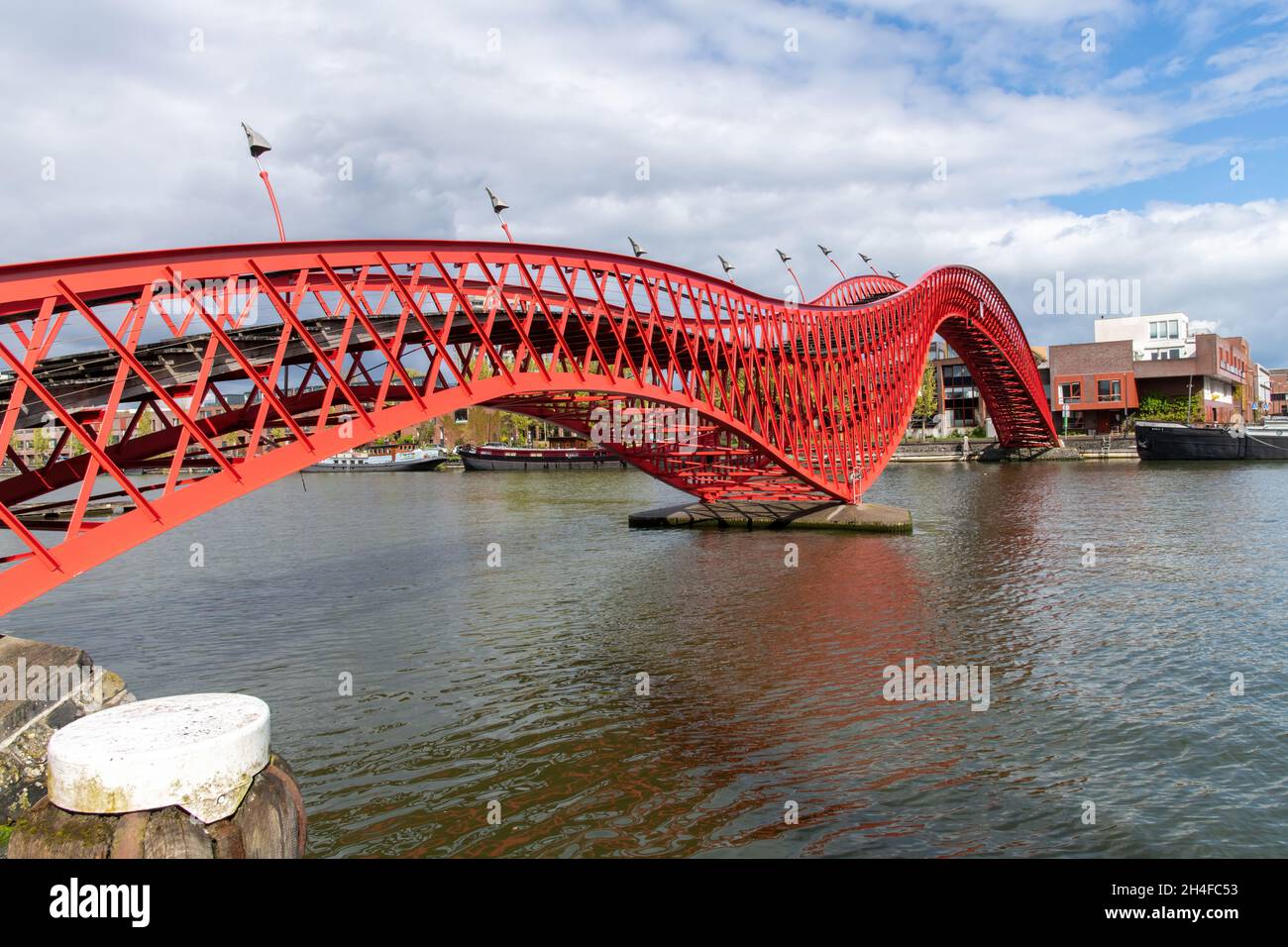 Amsterdam, pays-Bas-Mai 2021: Vue latérale à angle bas du serpent de métal rouge comme Pythonbrug avec des marches en bois qui est une passerelle traversant Banque D'Images