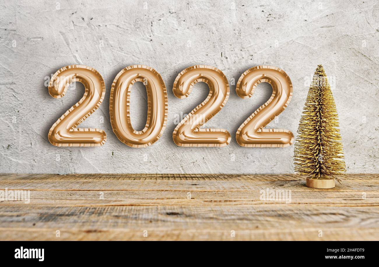 Golden New Year 2022 texte écrit avec ballon police de feuille et petit arbre de noël doré. Banque D'Images