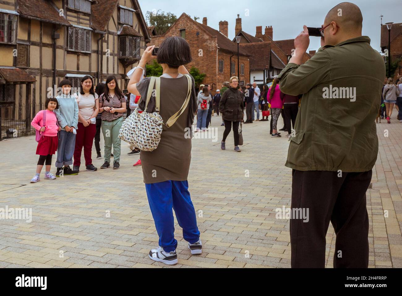 Une pose familiale pour des photos en dehors du lieu de naissance de William Shakespeare à Stratford-upon-Avon, Angleterre, Royaume-Uni. Banque D'Images