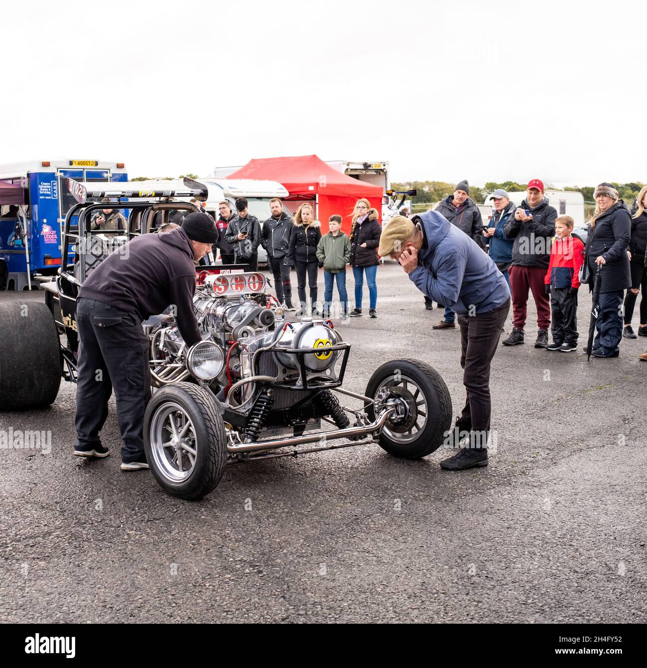 Les amateurs de course et les spectateurs se sont rassemblés autour de la voiture de course Twister Drag dans les fosses pendant qu'elle est réglée et préparée pour courir le quart de mile à la Banque D'Images