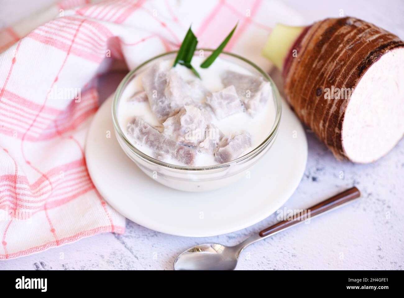 Taro alimentaire avec dessert taro bouilli avec du sucre et du lait de coco sur un bol et de la racine de taro frais cru bio prêt à cuire, cuisine thaïlandaise asiatique Banque D'Images