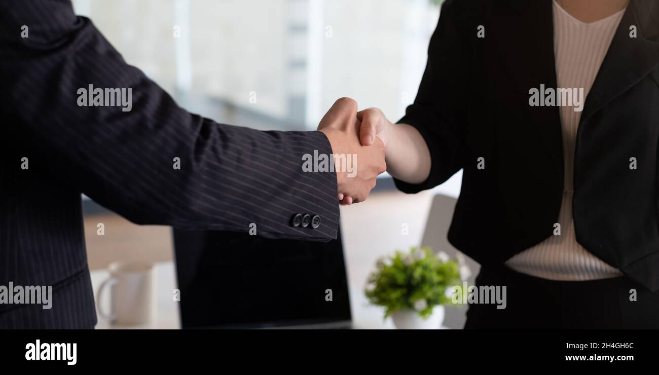 Les gens d'affaires se handshake à la table de réunion dans le bureau avec confiance .Les jeunes hommes d'affaires et les femmes d'affaires expriment leur accord Banque D'Images